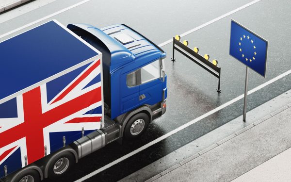 HGV Lorry with UK Flag decal stopped at a barrier with a EU Flag